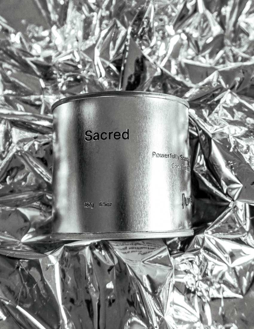 Large size silver travel tin candle of fragrance scent sacred close up on metallic background.