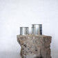 Large and medium sized silver travel tin candle of scent figure wide shot.