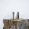 Large sized silver travel tin candle of scent figure wide shot.