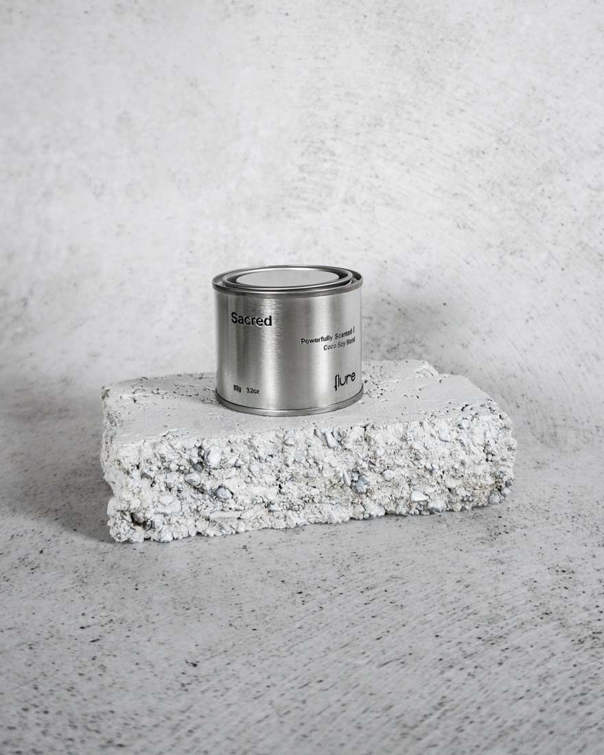 Medium sized silver travel tin candle of fragrance scent sacred wide shot.