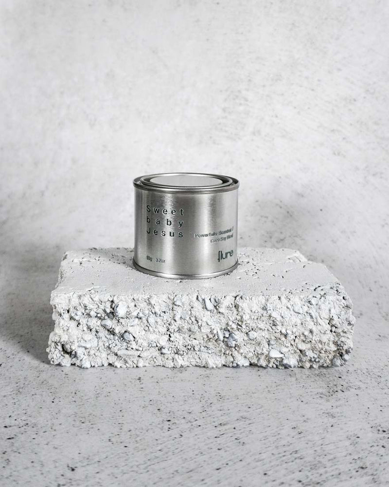 Medium sized silver travel tin candle of fragrance scent sweet baby jesus - wide shot.