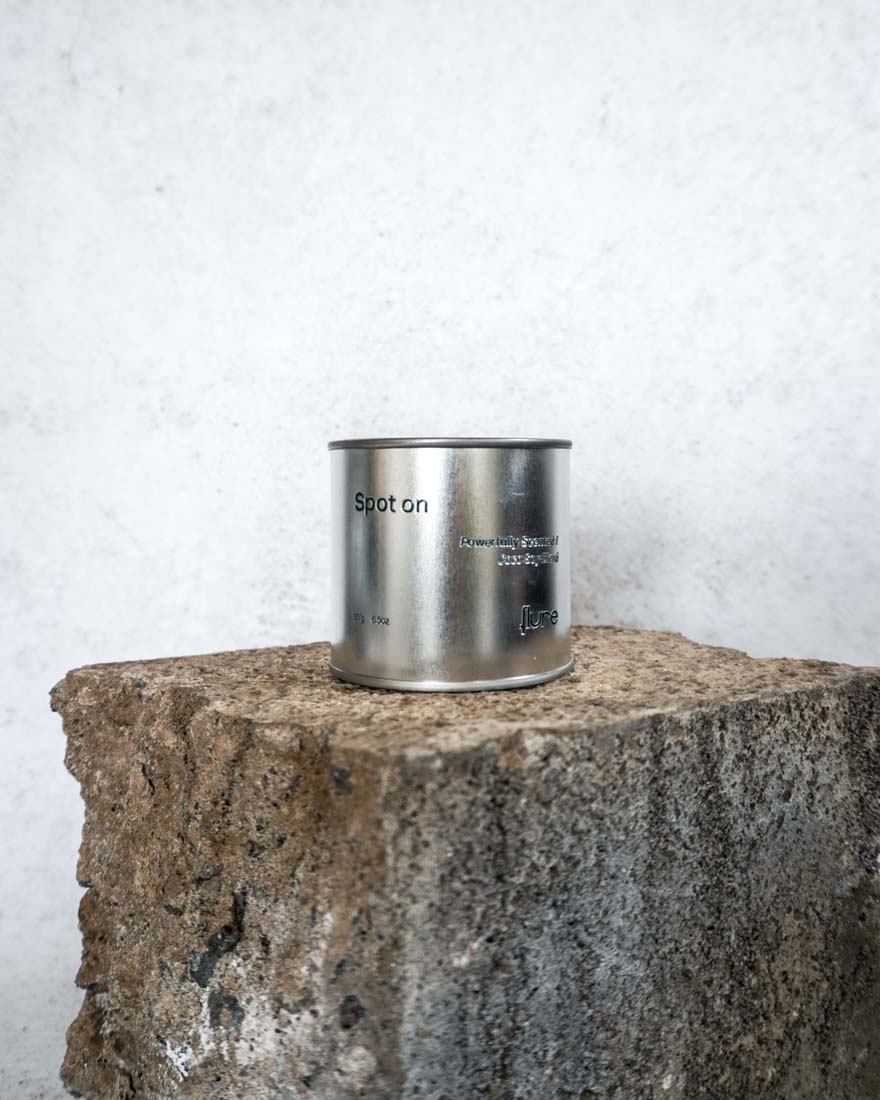 Large sized silver travel tin candle in the fragrance scent spot on - wide shot.