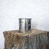 Large sized silver travel tin candle in the fragrance scent spot on - wide shot.