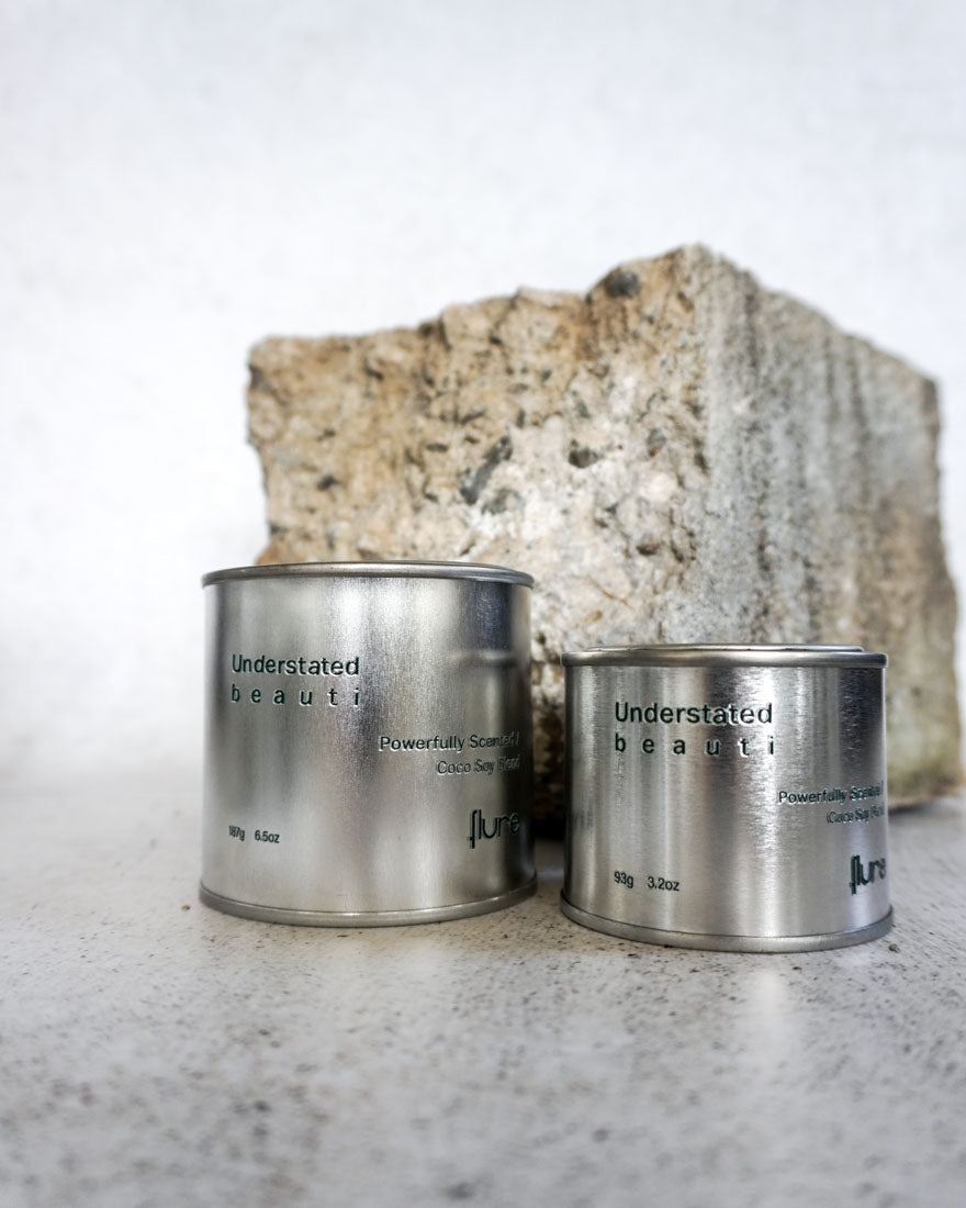 Group image of flure's travel tin collection in fragrance scent understated beauti in medium and large size - close up.