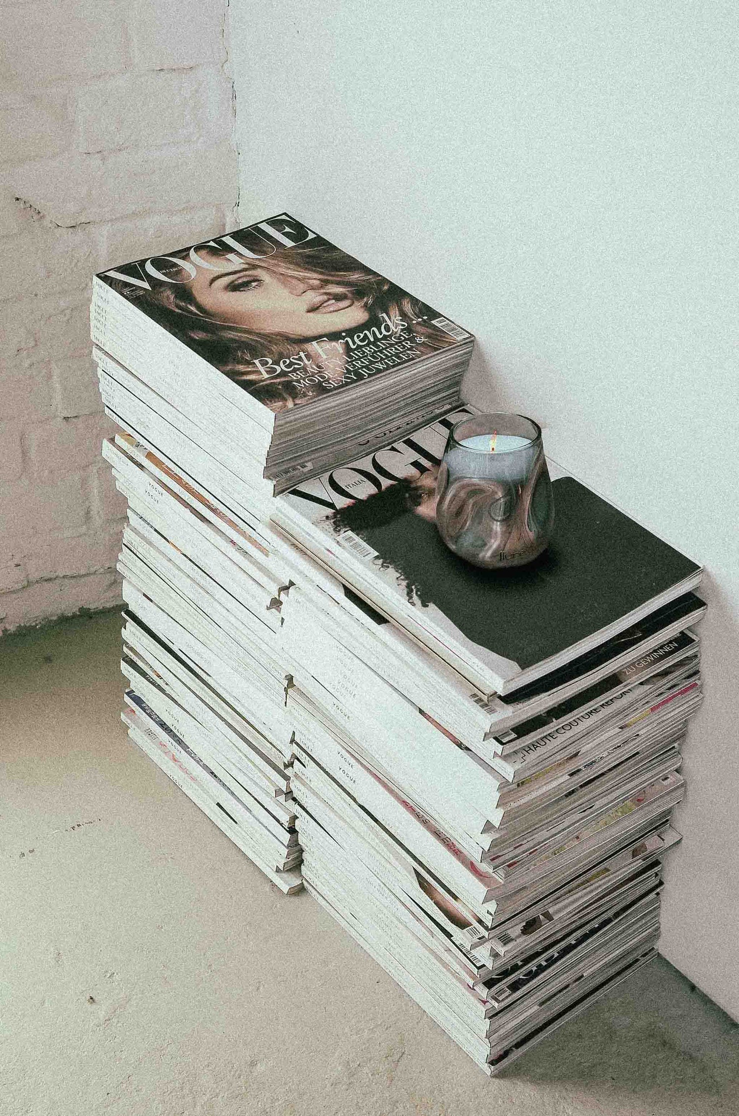 Image of flure's luxury candle brands hand blown candle on top of magazines