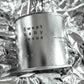 Large sized silver travel tin candle of fragrance scent  sweet baby jesus - close up image on metallic background.