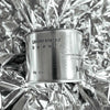 Medium sized silver travel tin candle of fragrance scent understated beauti - close up on metallic background.