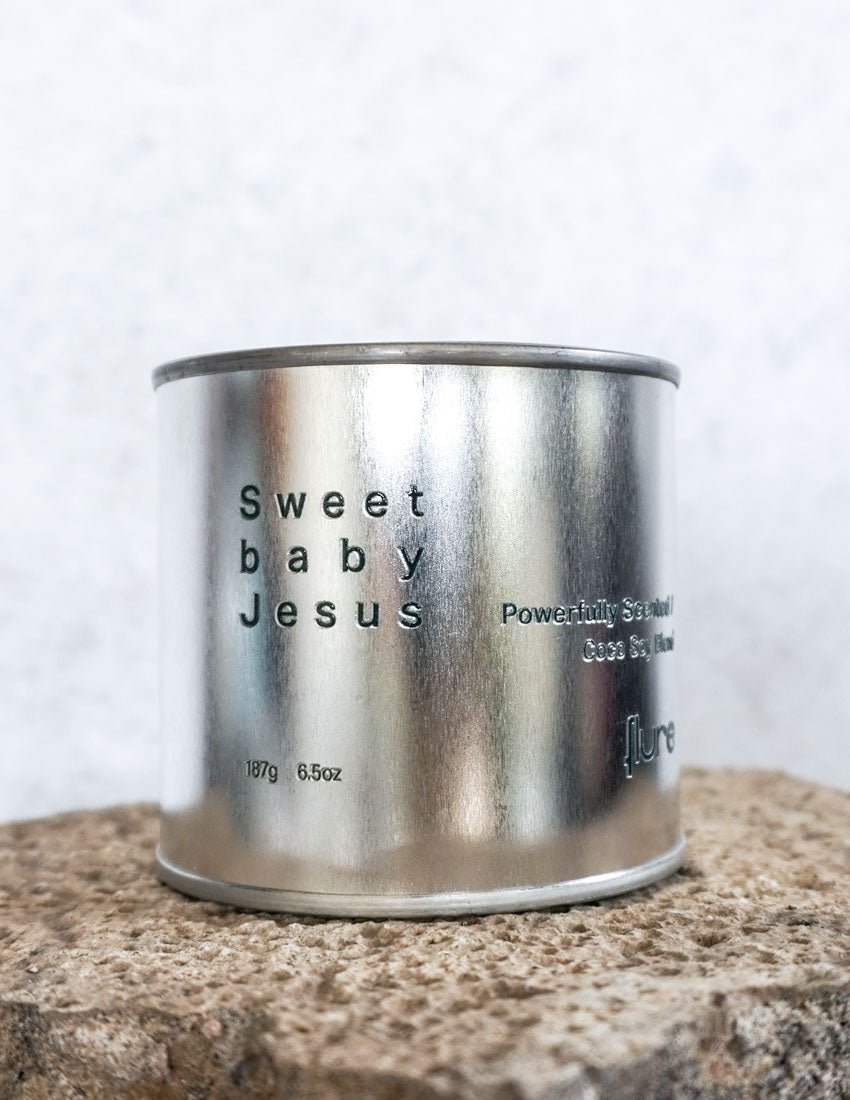 Large sized silver travel tin candle of fragrance scent  sweet baby jesus - close up detail shot.