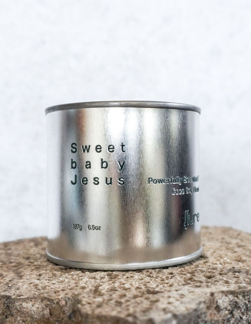 Large sized silver travel tin candle of fragrance scent  sweet baby jesus - close up detail shot.