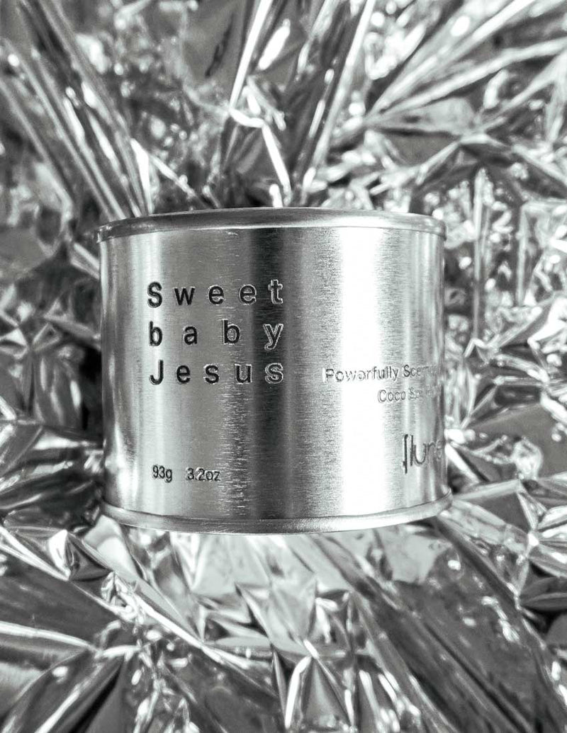 Medium sized silver travel tin candle of fragrance scent sweet baby jesus - close up.