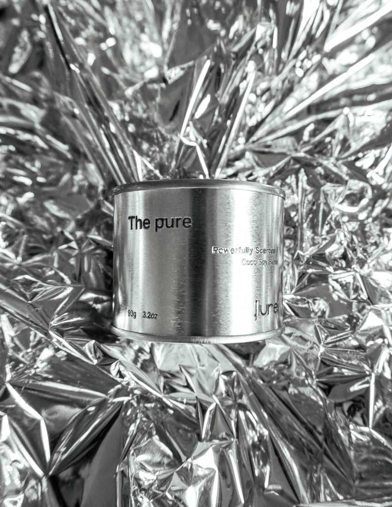 Medium sized silver travel tin candle of fragrance scent the pure - metallic background wide shot.