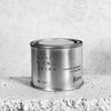 Medium sized silver travel tin candle of fragrance scent sweet baby jesus - close up on brick.