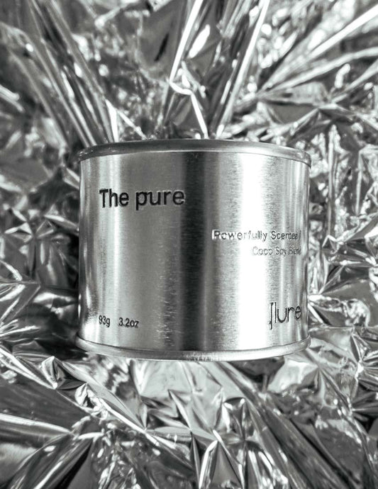Medium sized silver travel tin candle of fragrance scent the pure - close up on metallic background.