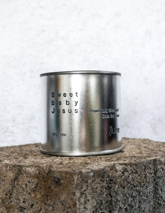 Large sized silver travel tin candle of fragrance scent  sweet baby jesus - close up image.