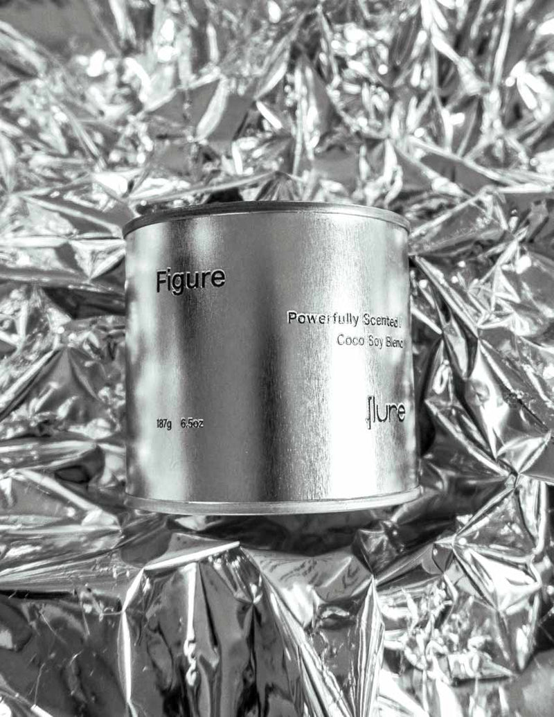 Large sized silver travel tin candle of scent figure on metallic background.
