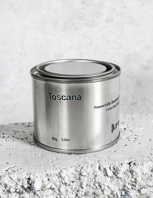 Medium sized silver travel tin candle of fragrance scent toscana - close up.