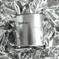 Large sized silver travel tin candle in the fragrance scent spot on  - close up on metallic background.