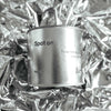 Large sized silver travel tin candle in the fragrance scent spot on  - close up on metallic background.