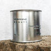 Silver travel tin candle of fragrance scent understated beauti - close up shot.