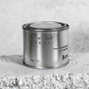 Medium sized silver travel tin candle of fragrance scent understated beauti - close up.